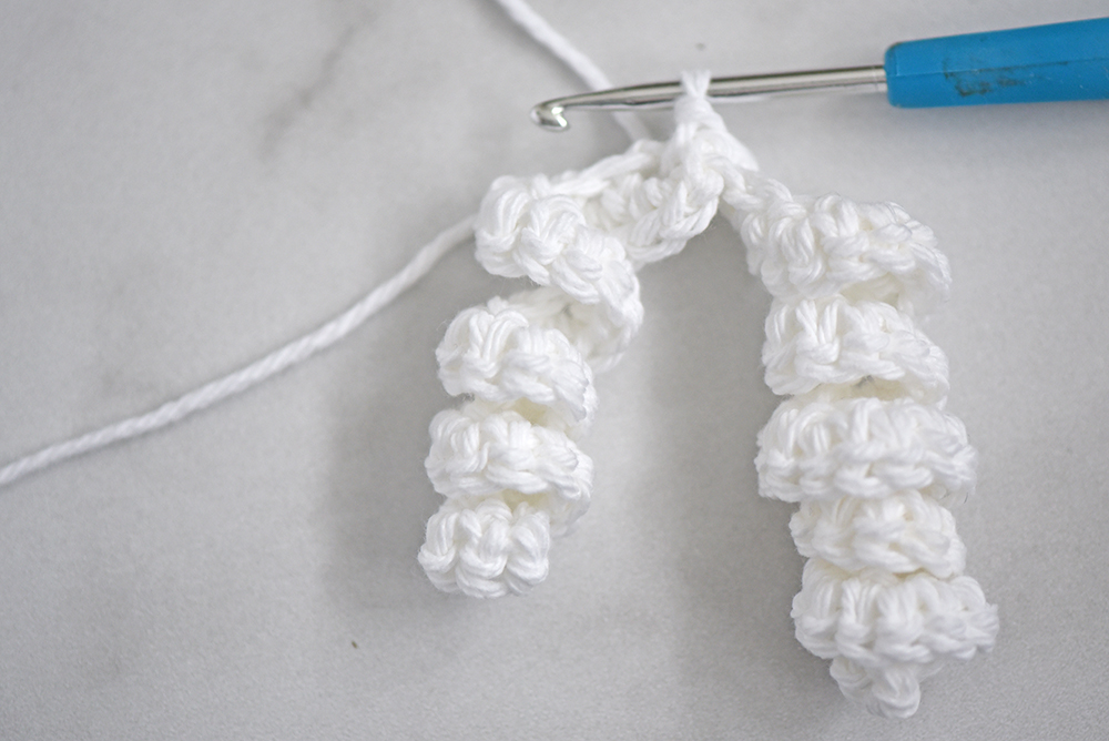 Photo shows a white crochet ribbon with 2 spirals.