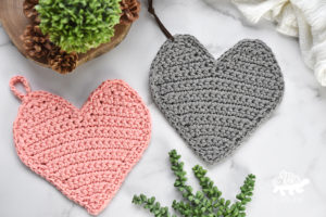 pink and grey crochet pot holders in the shape of hearts