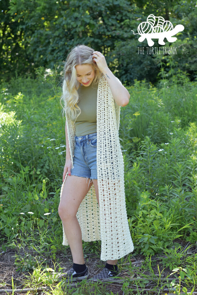 Woman wearing a long crochet vest.