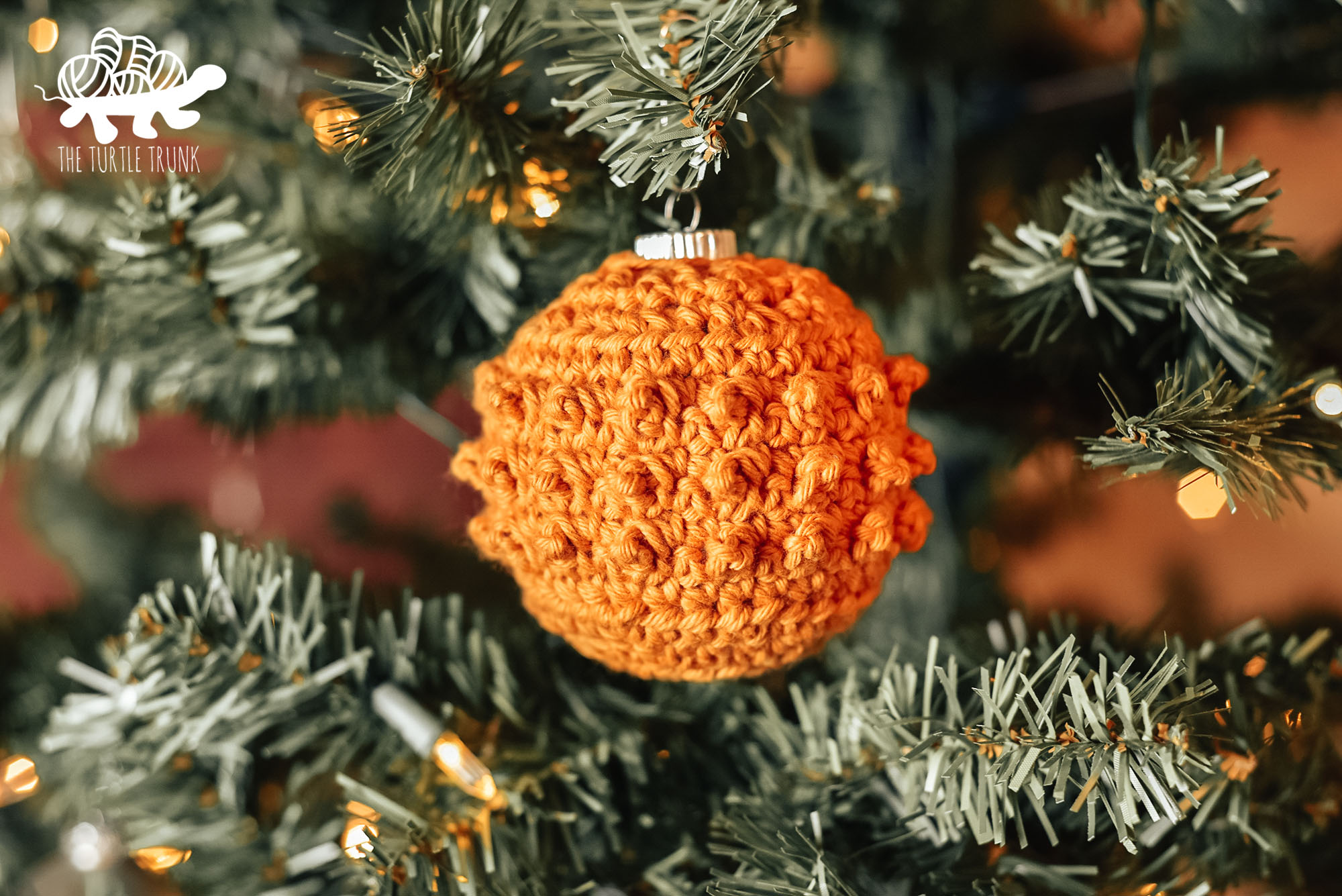 Photo shows a yellow, crochet tree ornament hanging on a Christmas tree. Picot Tree Ornament crochet pattern by The Turtle Trunk 