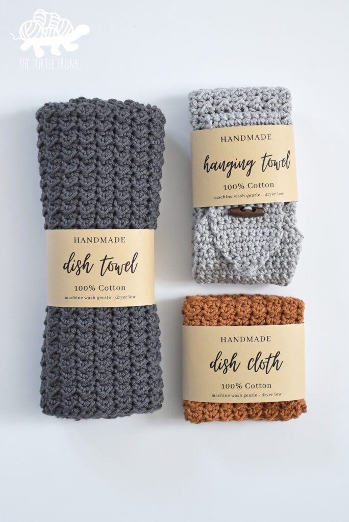 3 crochet cloths with paper labels wrapped around them. Crochet pattern is the Farmhouse Dish Set by The Turtle Trunk.