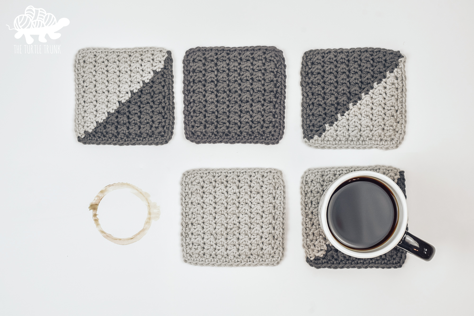 5 grey, crochet coasters laying on a white surface. Photo also includes a coffee stain on the surface and a cup of black coffee. Crochet pattern is the Farmhouse Coaster by The Turtle Trunk.