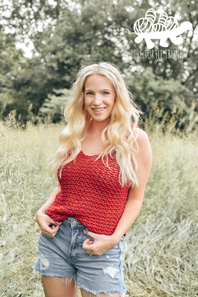 Photo shows a woman a red, crochet tank top.