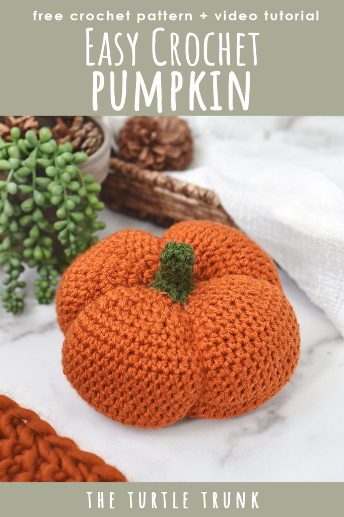 Pinterest pin for the Basic Pumpkin crochet pattern by The Turtle Trunk. Photo shows a simple crochet pumpkin sitting on a white surface.