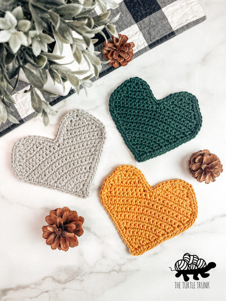 3 crochet heart shaped coaster on a white background.