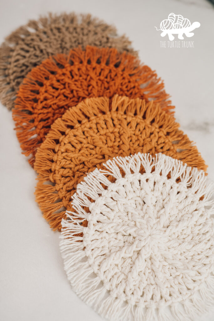 4 crochet coasters laying on a white surface. Hello Sunshine Coaster crochet pattern by The Turtle Trunk.