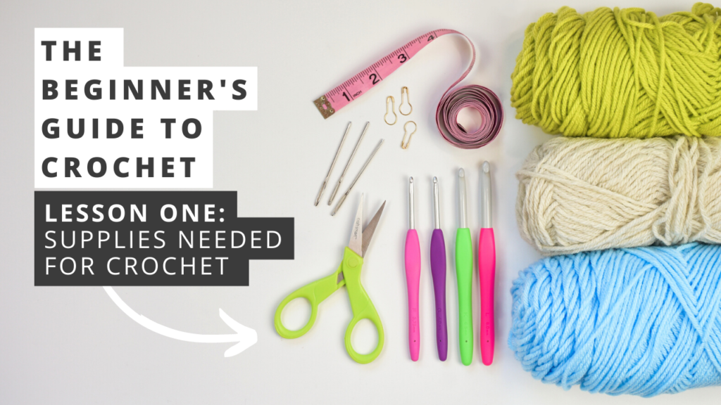 Beginner's Guide to Crochet Lesson One - Supplies Needed for Crochet. Photo shows crochet supplies, laying on a white surface. Supplies include yarn, crochet hooks, scissors, stitch markers, yarn needles, and a tape measure.