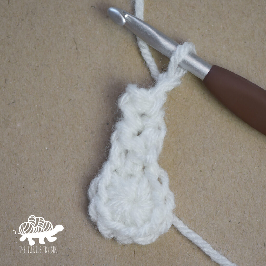 Progress photo of a white, crochet star.