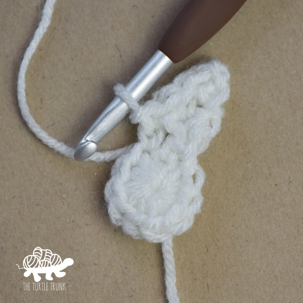 Progress photo of a white, crochet star.