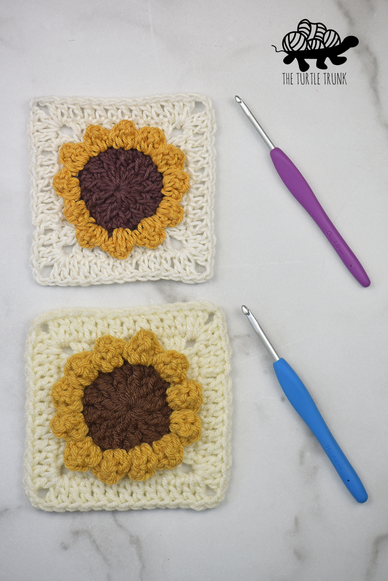 2 crochet squares with sunflowers on them beside crochet hooks. Crochet pattern is the Sunflower Square by The Turtle Trunk.