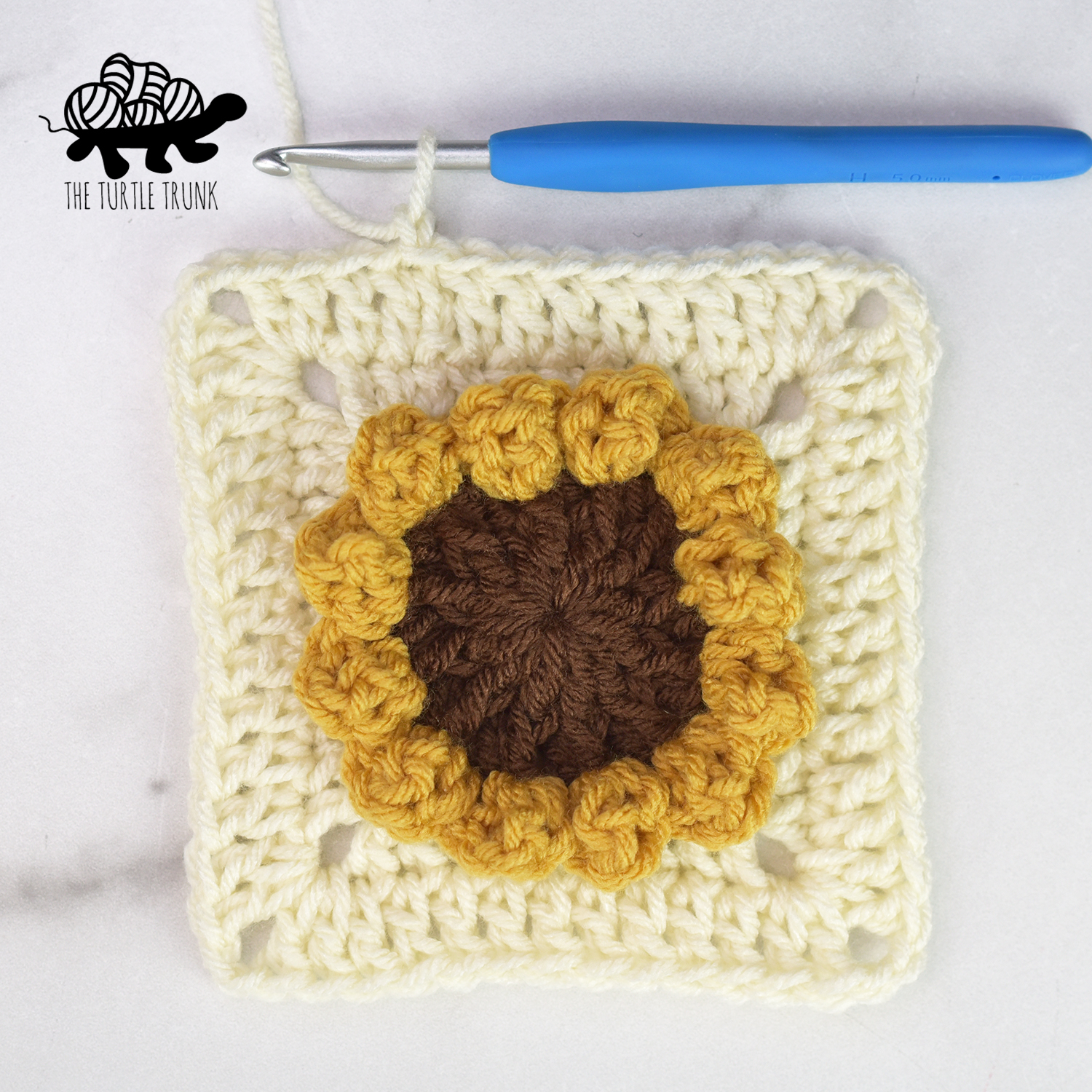 The Sunflower Square after round 5. Shows a crochet sunflower with 2 square border rows around it.