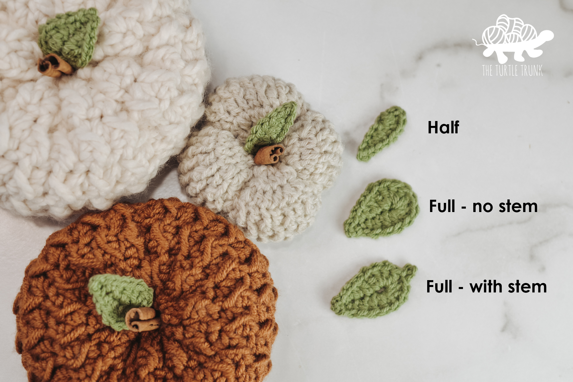 Photo shows 3 crochet pumpkins with crochet leaves attached to the top, as well as 3 crochet 3 leaves laying beside them on a white surface. 