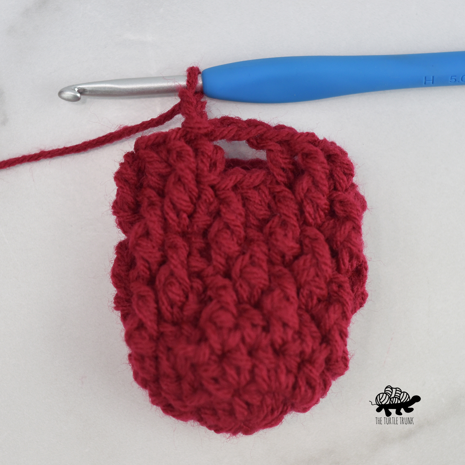 Photo shows the thumbhole on the Mini Country Cottage Mitten crochet pattern by The Turtle Trunk.