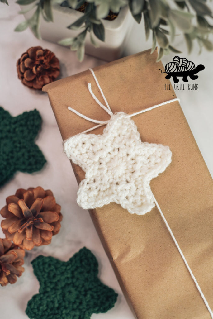 A crochet star is tied to the top of a wrapped gift. Star crochet pattern by The Turtle Trunk.