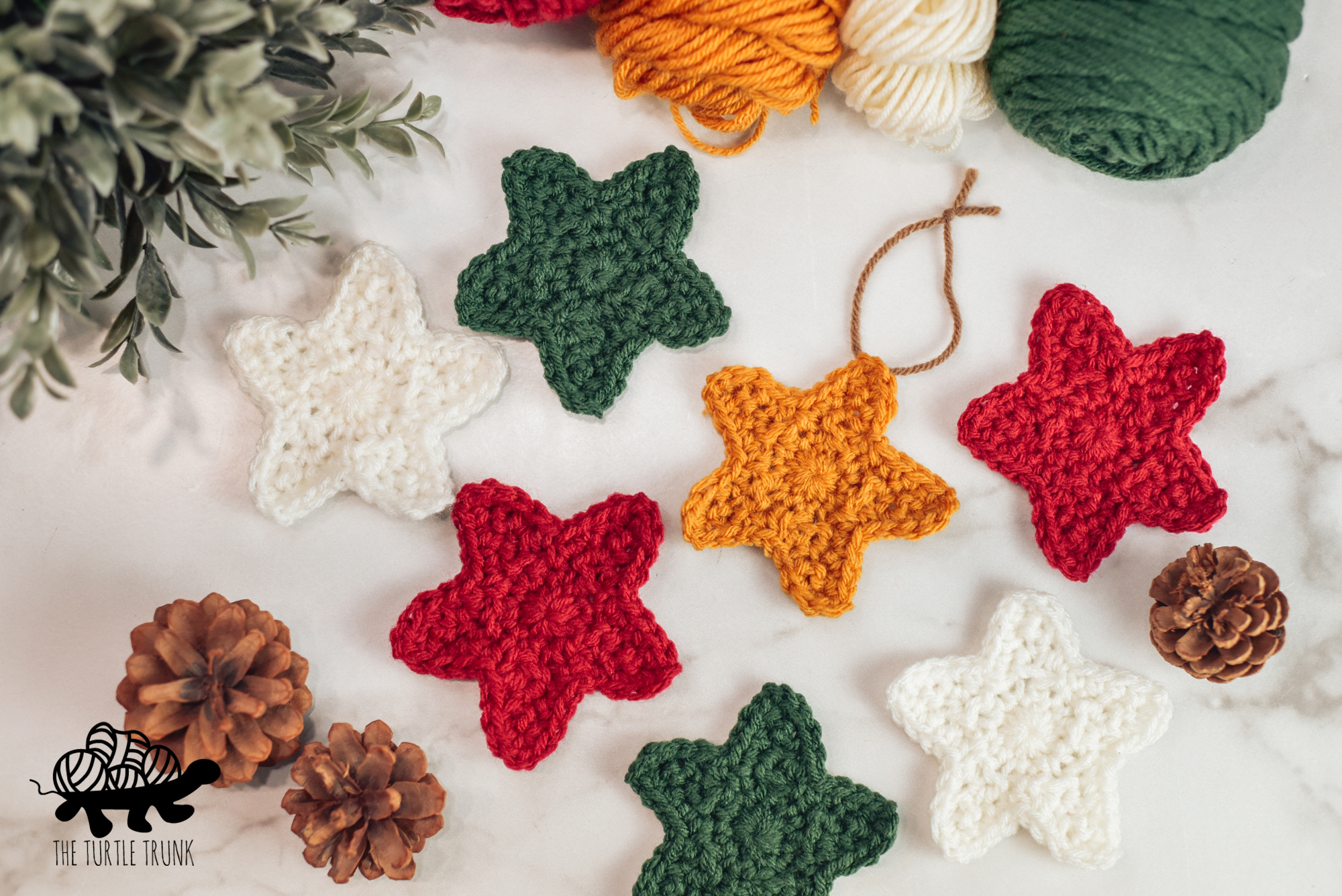 Photo shows 7 crochet stars laying on a white surface. Star crochet pattern by The Turtle Trunk.