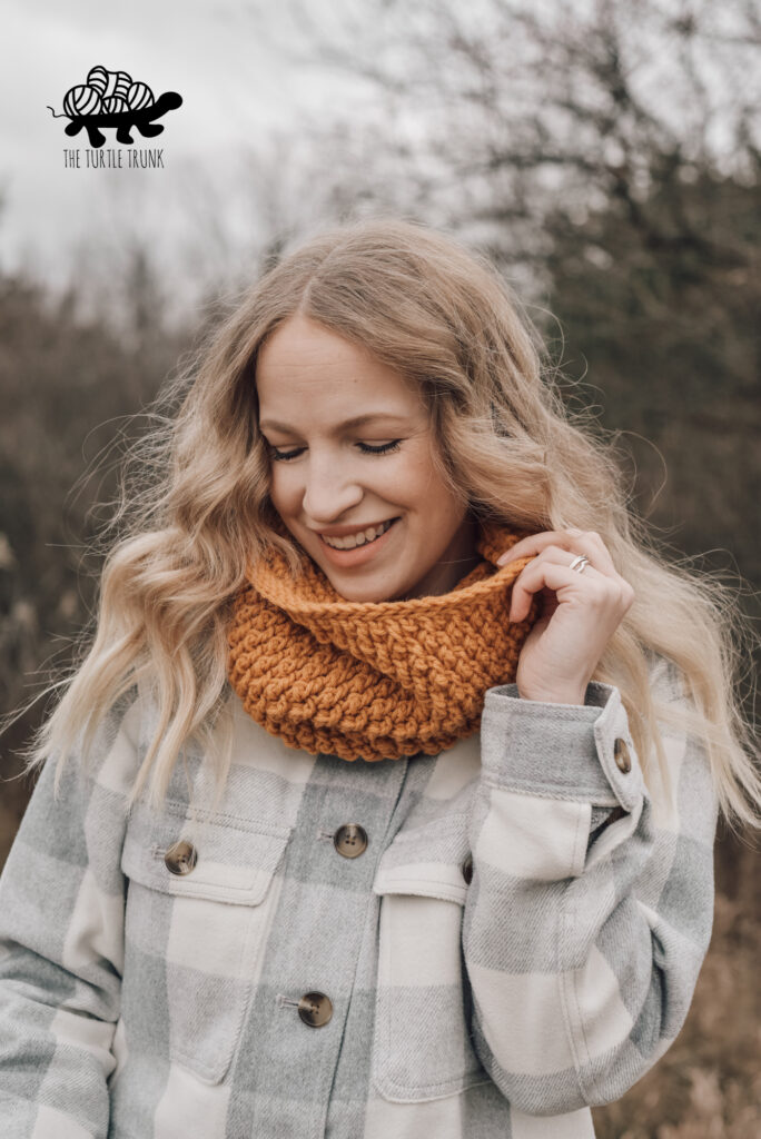 Photo shows a woman wearing a yellow, crochet cowl. Crochet Pattern is the Country Cottage Cowl by The Turtle Trunk.