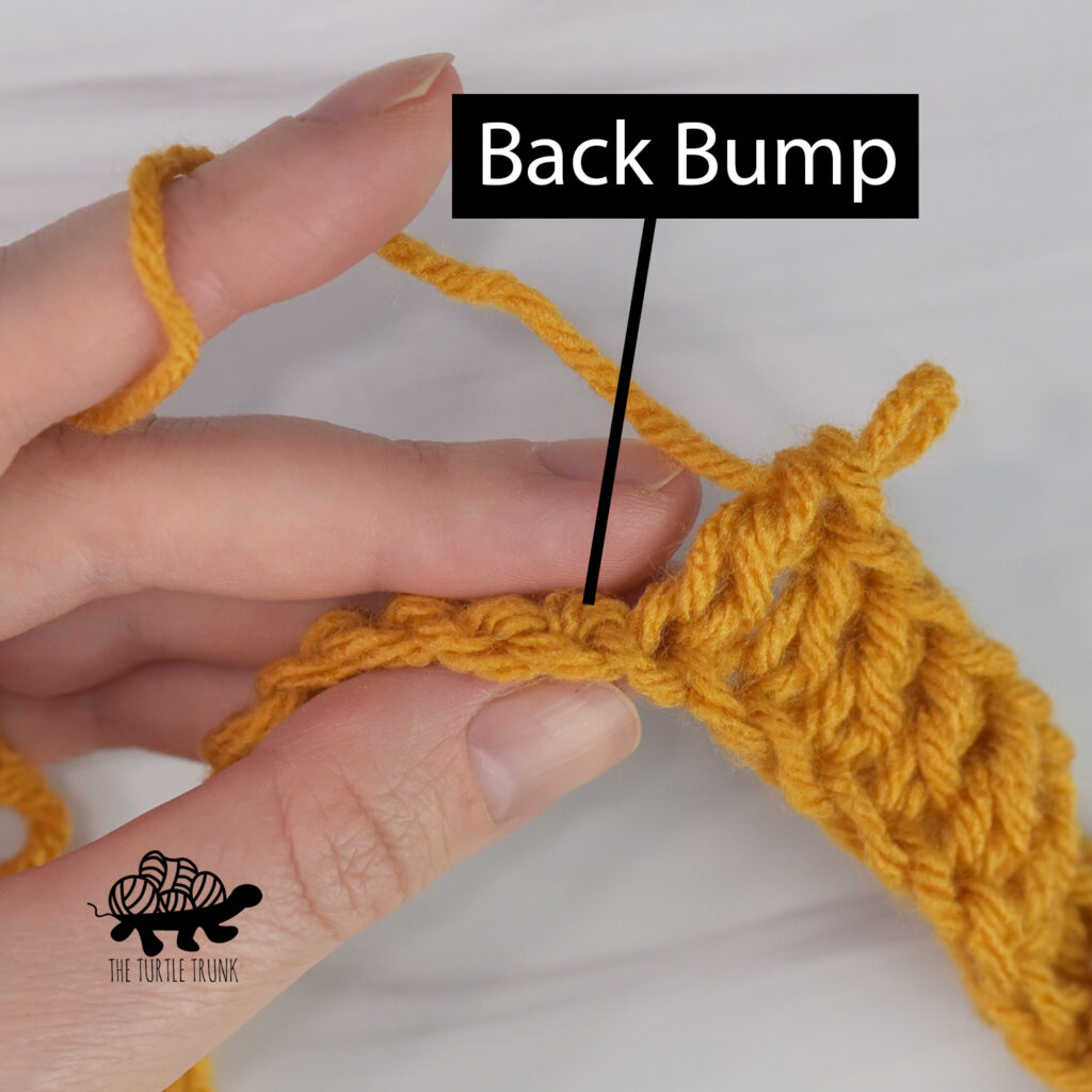 Photo shows the back bump of a crochet foundation chain using yellow yarn.