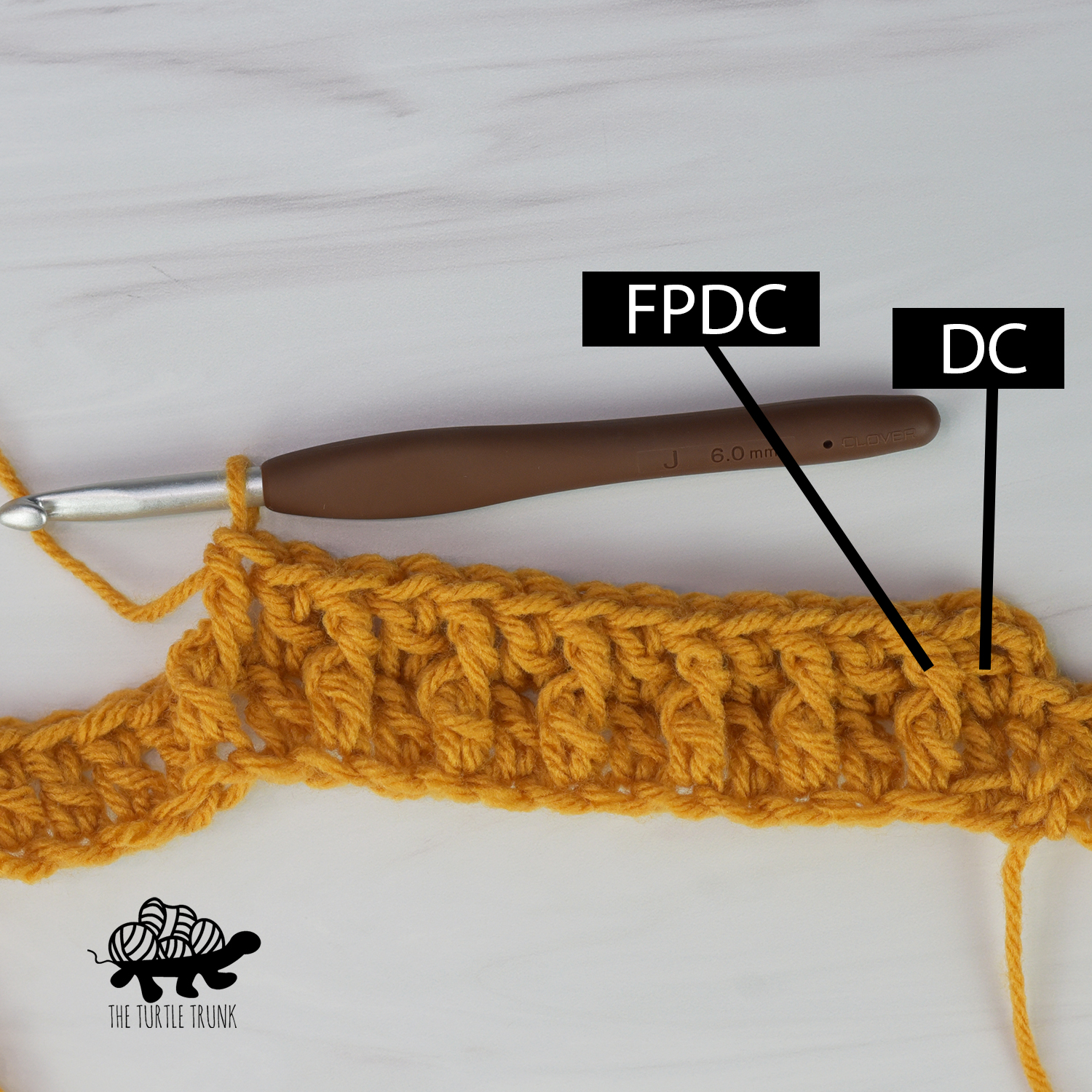 Photo shows yellow yarn and crochet hook working a row of double crochet stitches and front post double crochet stitches alternating.