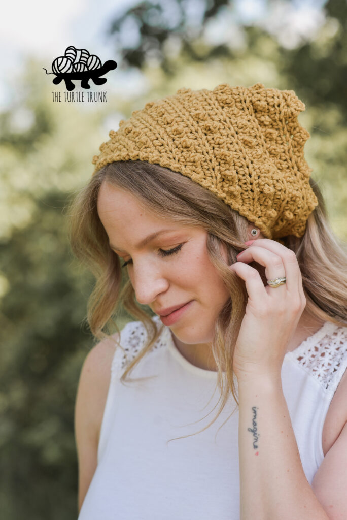 Photo shows a woman wearing a yellow, crochet bandana. Crochet pattern is the Picot Bandana by The Turtle Trunk.