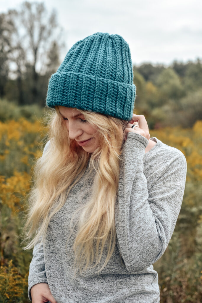 Woman wearing a ribbed crochet hat. Crochet pattern is the Easy Breezy Ribbed Beanie by The Turtle Trunk.