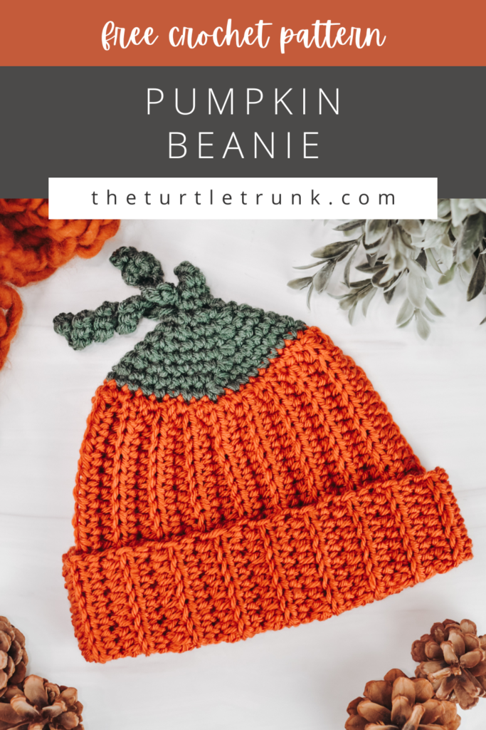 Pinterest pin for the Pumpkin Beanie crochet pattern by The Turtle Trunk. Photo shows a ribbed, crochet beanie that looks like a pumpkin laying on a white surface.