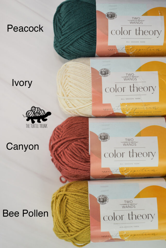 Photo shows 4 skeins of Lion Brand Yarn Color Theory on a white surface.