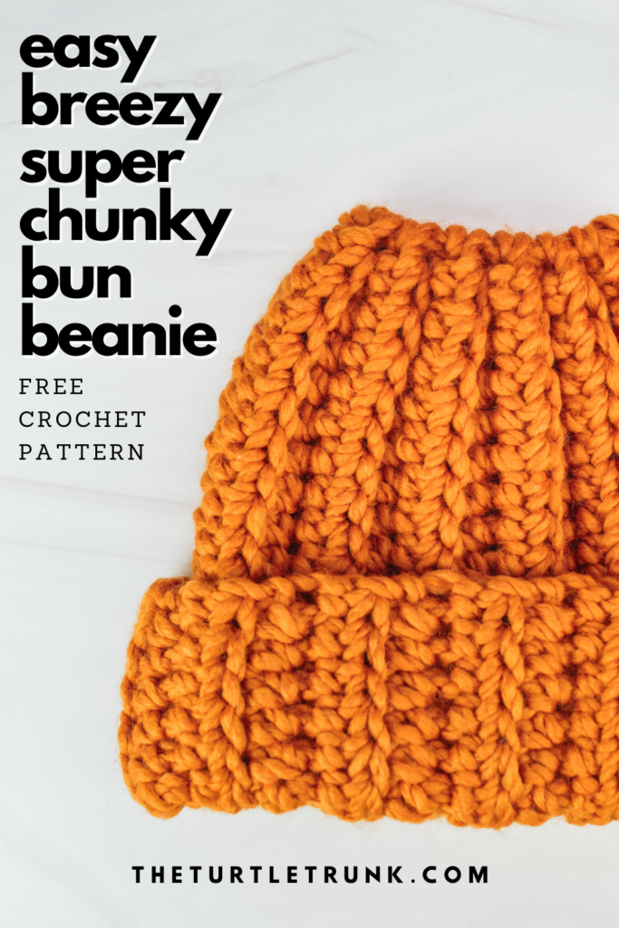 Pinterest pin for the Easy Breezy Super Chunky Bun Beanie crochet pattern by The Turtle Trunk. Photo shows a yellow, crochet bun beanie laying on a white surface.