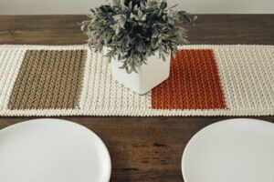 Crochet table runner on a wooden table.