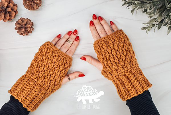 2 crochet fingerless gloves on hands.