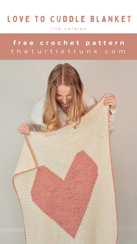 Woman holding a crochet heart blanket.