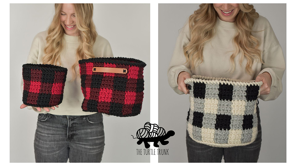 woman holding 2 crochet plaid baskets.