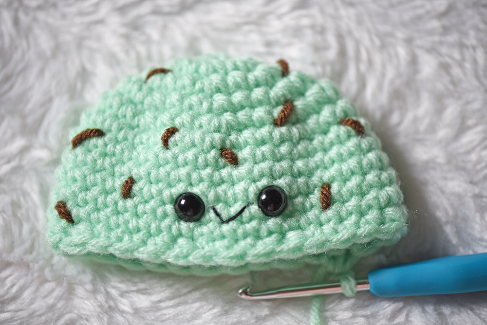 Close up of crochet amigurumi ice cream eyes and mouth placement.