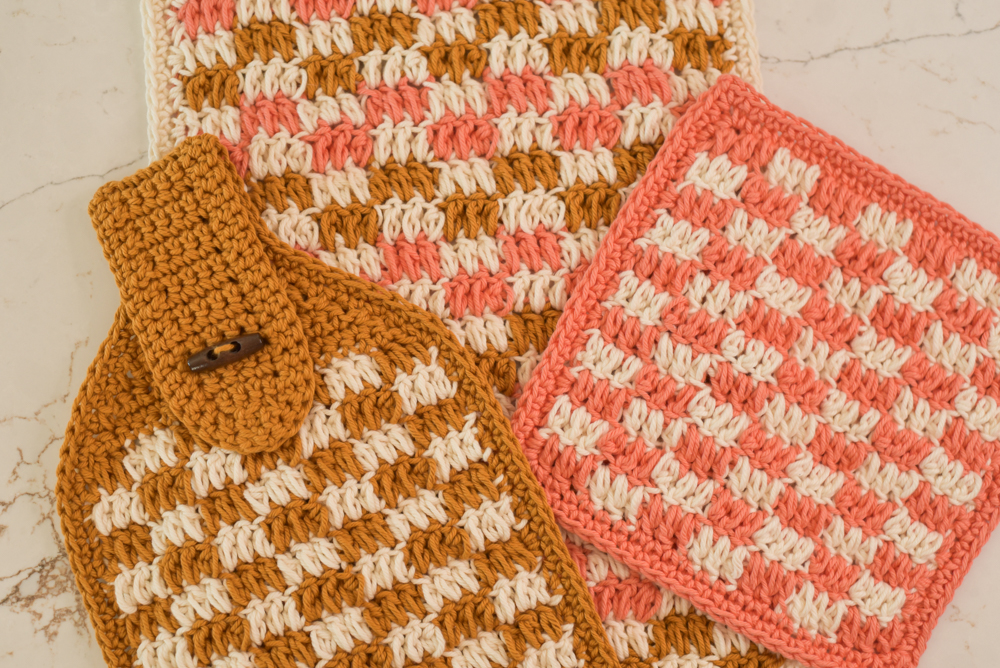 Crochet dish set including a dishcloth, dish towel, and hanging towel, all with a checkered design.