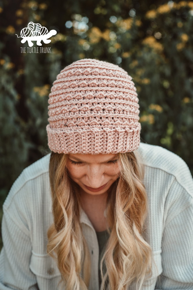 Woman wearing a pink, crochet beanie.