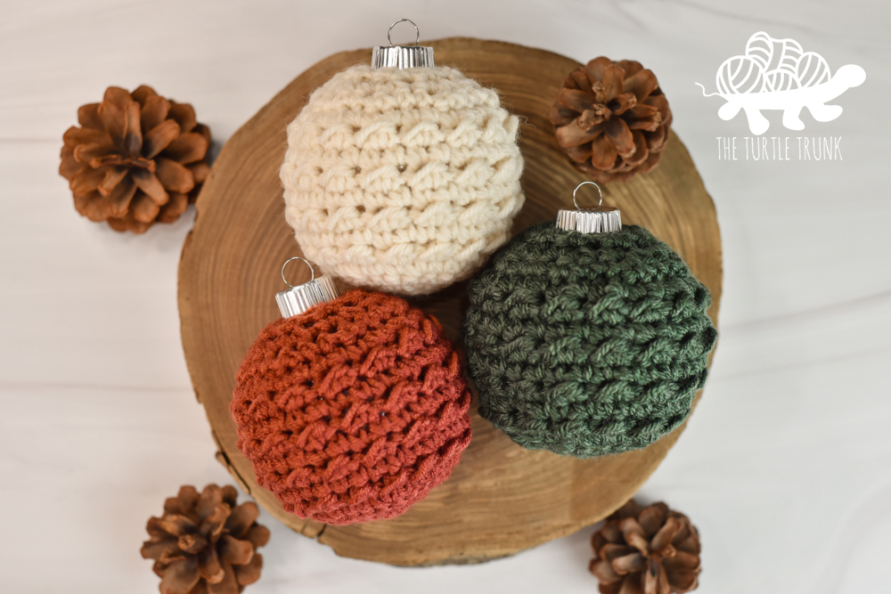 3 crochet ornaments laying on a white surface.