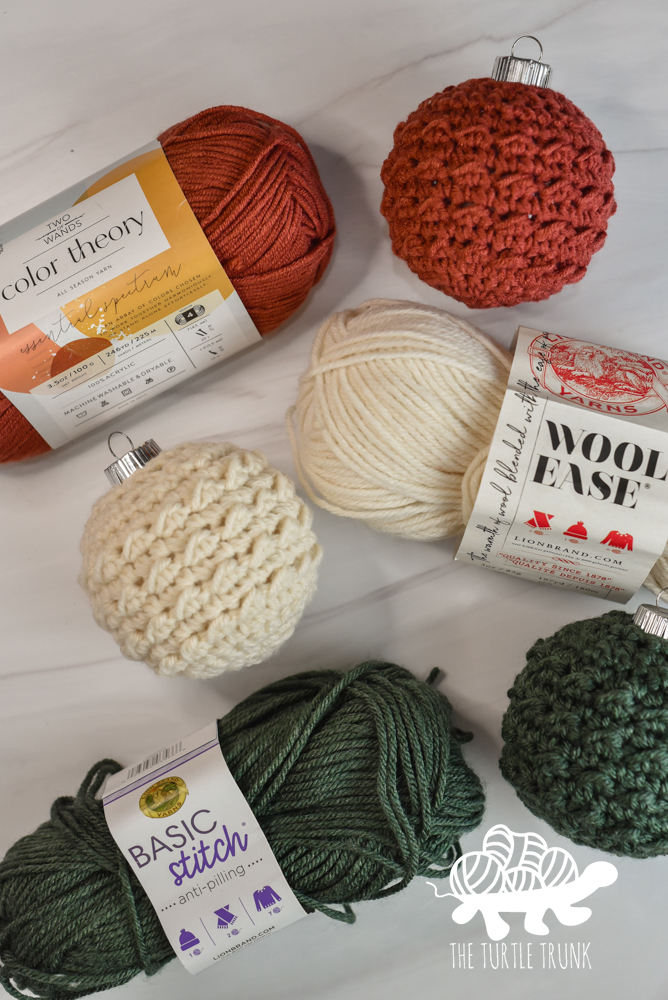 Photo shows 3 crochet ornaments and the 3 yarns used to make them, including Lion Brand Yarn Color Theory, Wool Ease, and Basic Stitch.