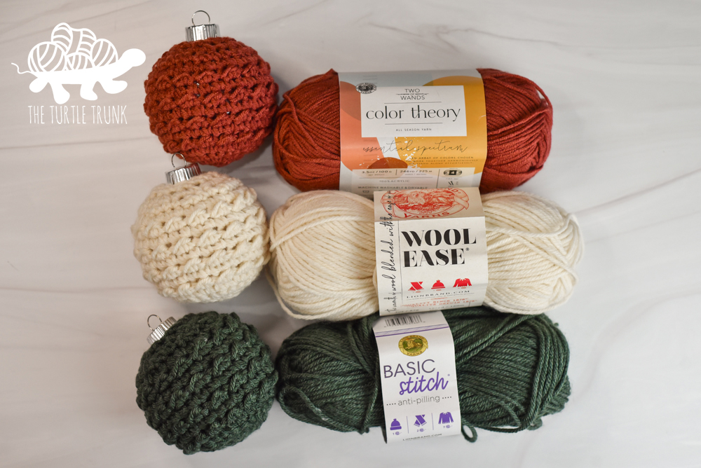 Photo shows 3 crochet ornaments and the 3 yarns used to make them, including Lion Brand Yarn Color Theory, Wool Ease, and Basic Stitch.