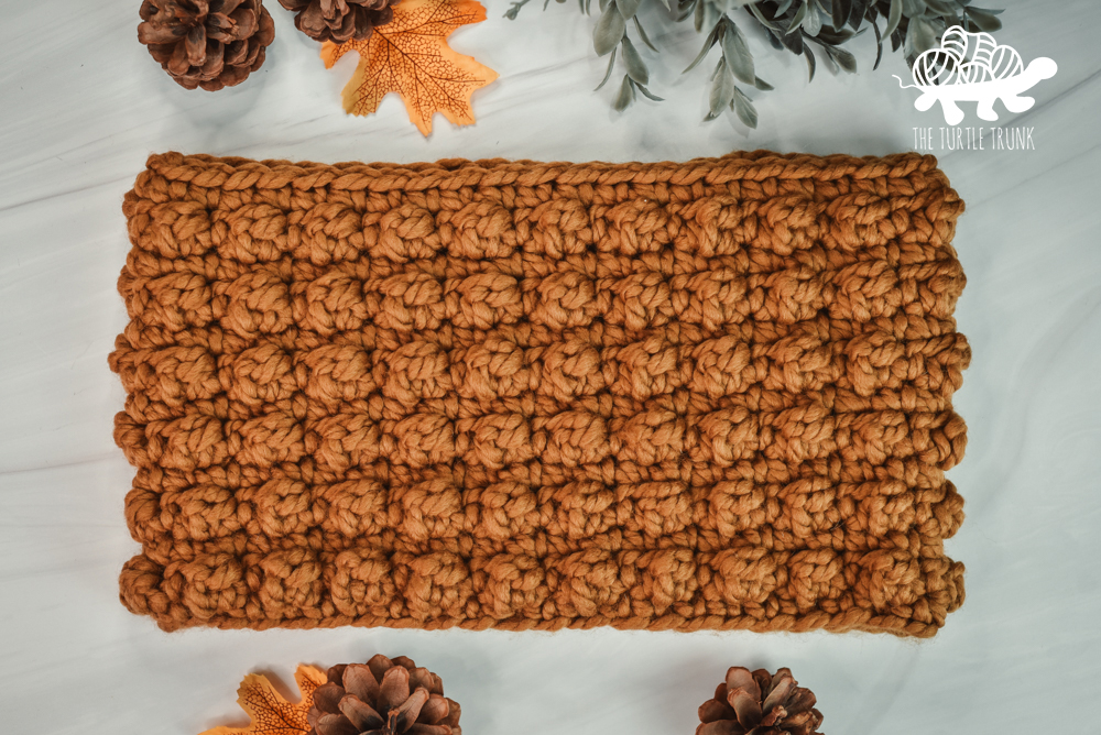 A crochet cowl featuring the berry stitch.