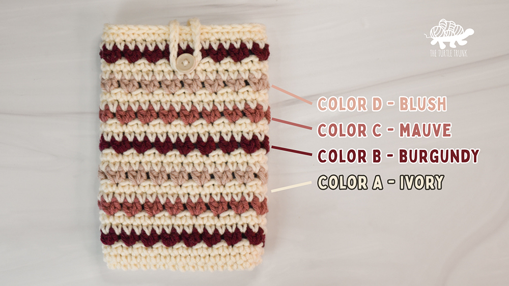 A crochet e-reader sleeve in different shades of pink.