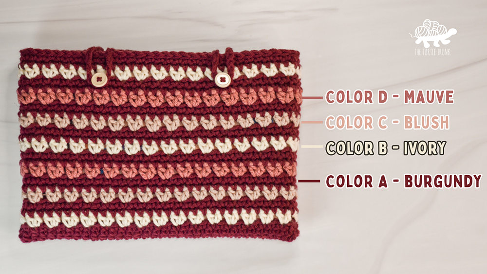 A crochet book sleeve in different shades of pink.