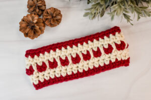 A chunky crochet ear warmer with hearts on it.