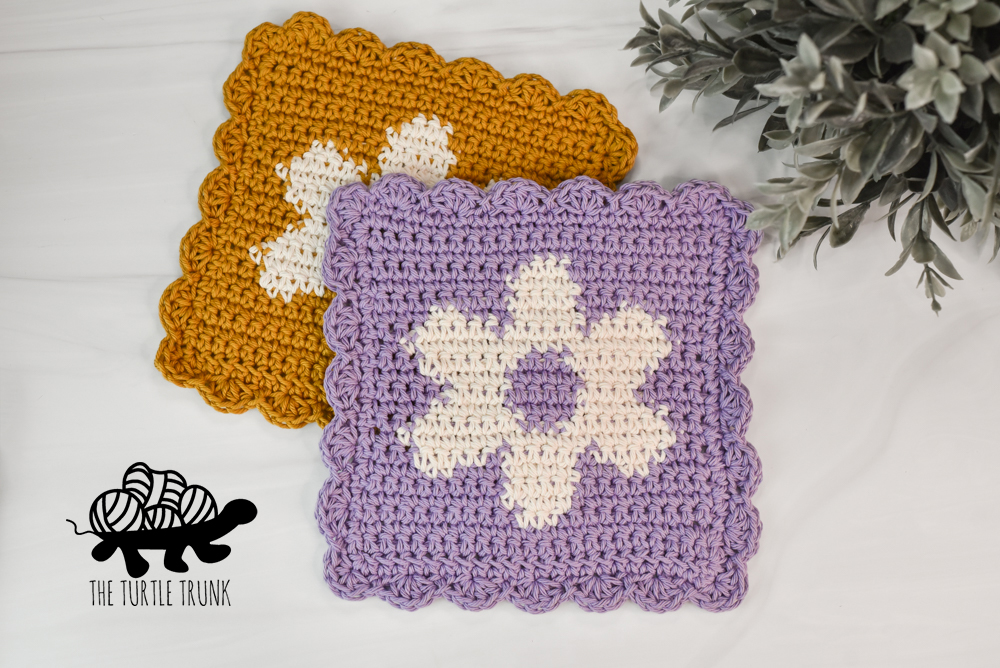 A yellow and white and a purple and white, crochet flower dishcloth.