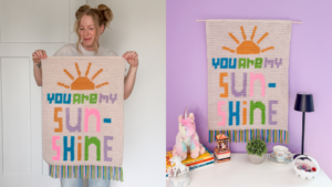 Woman holding a crochet wall hanging that says "You are my sunshine".